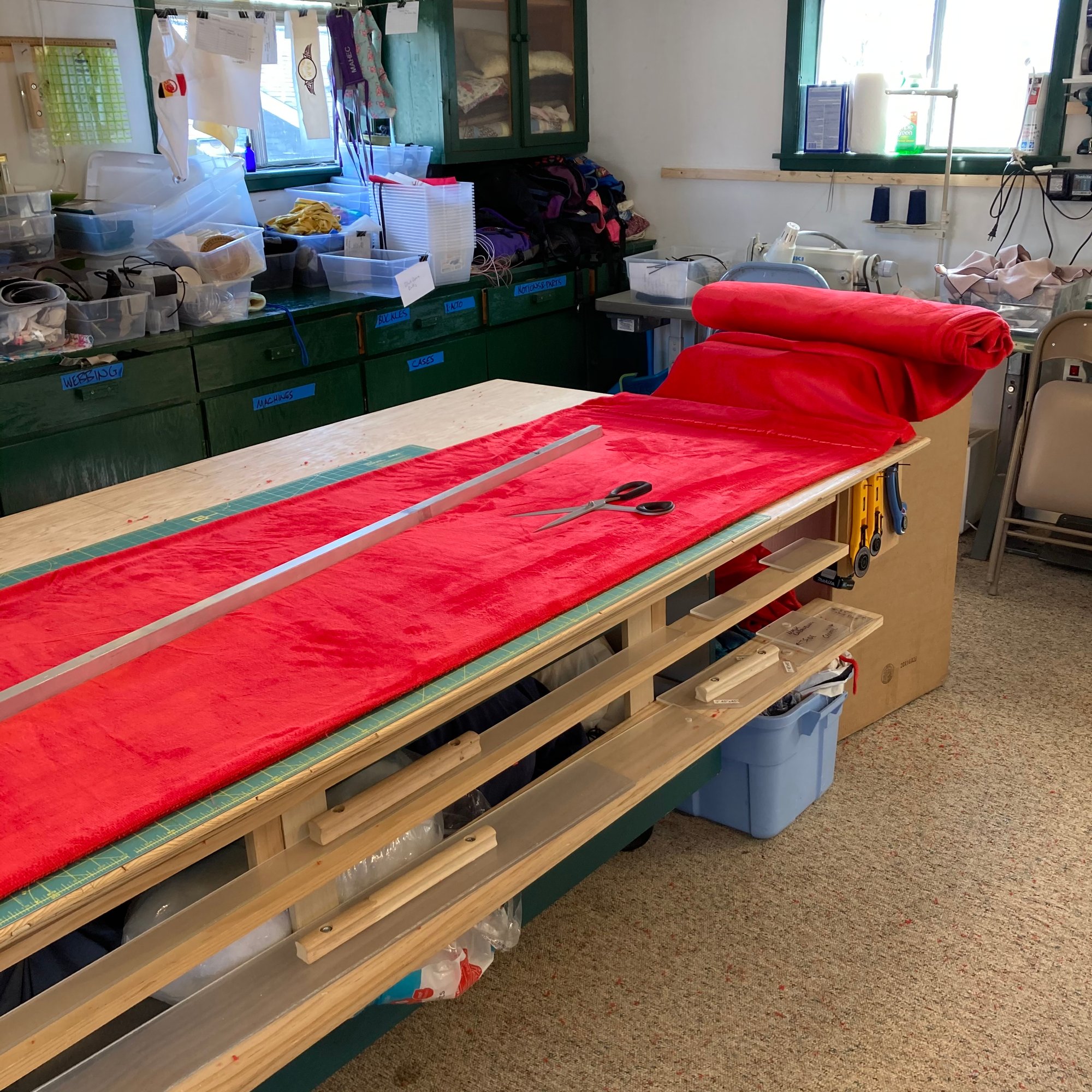 An image of a red fleece sleep sack on the cutting table.