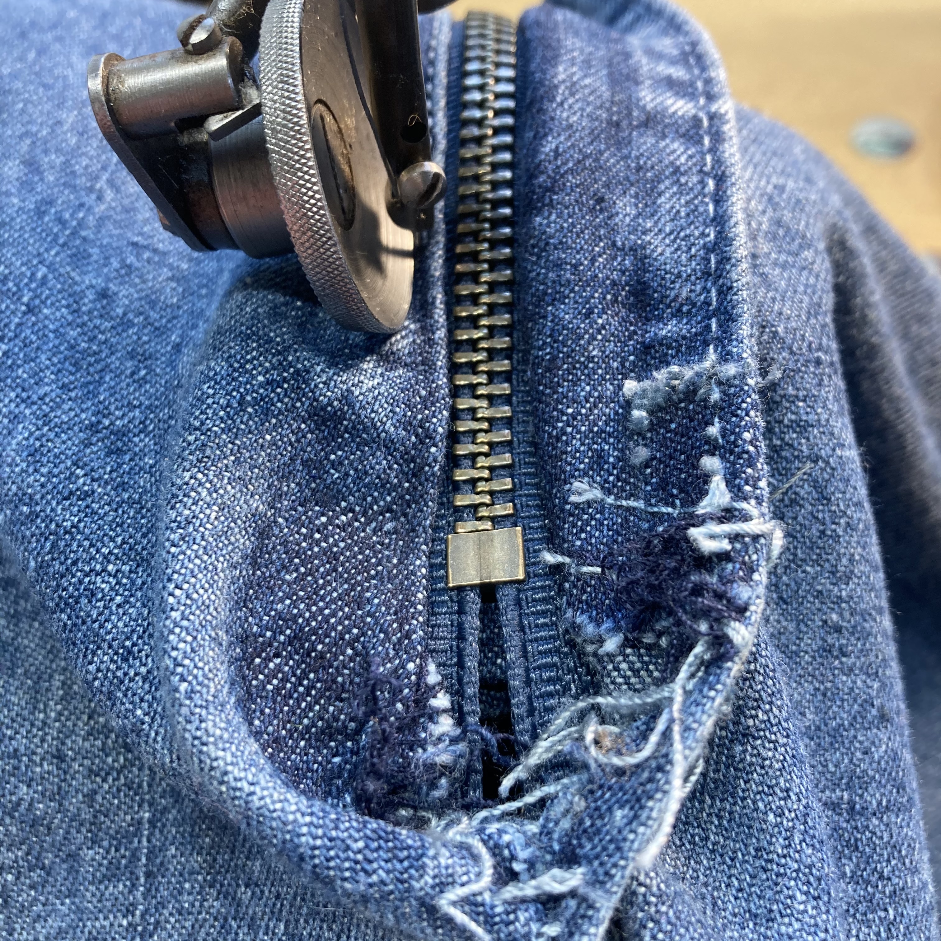 An image of the fly on a pair of blue jeans being replaced.